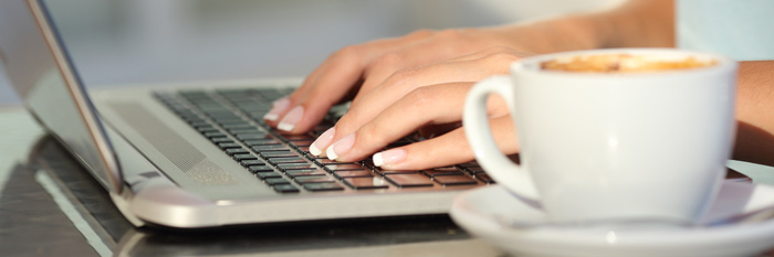 Hands typing on a laptop keyboard