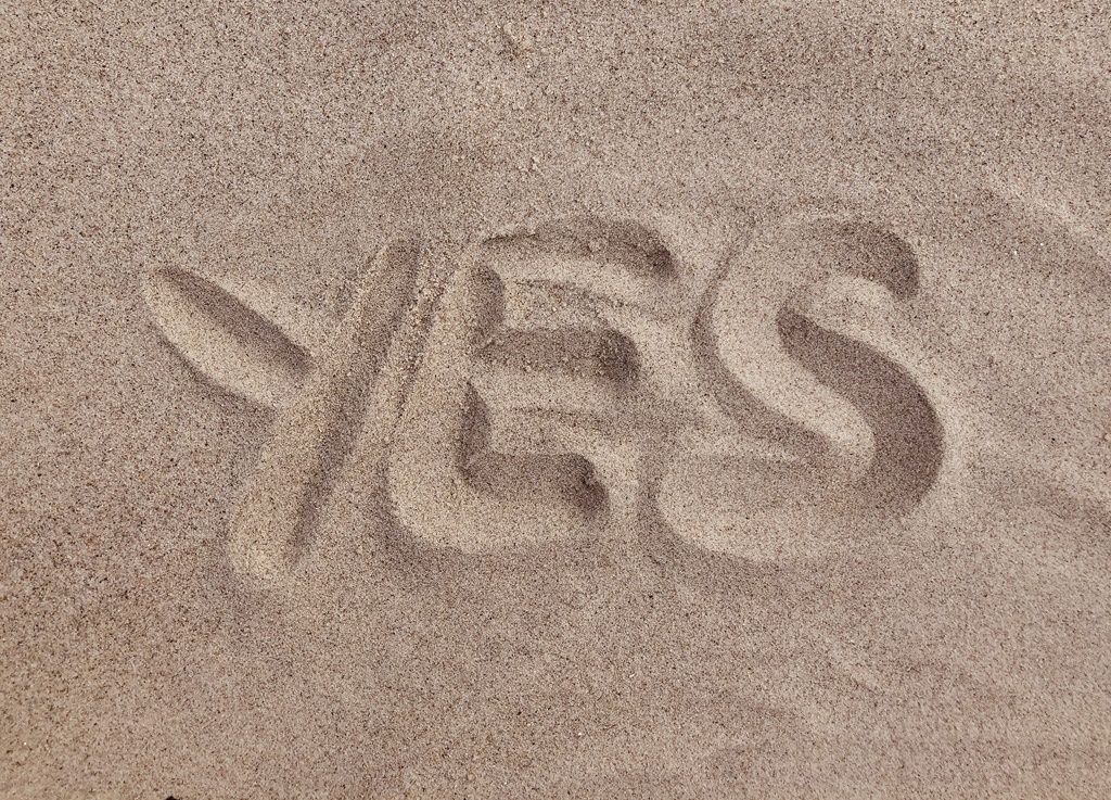 The word YES written in sand