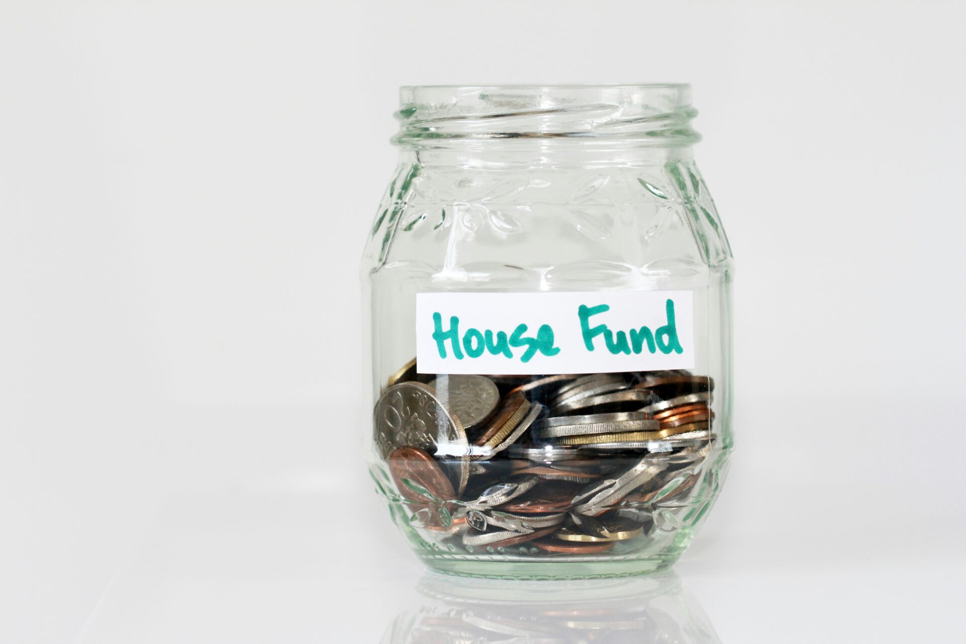 Glass jar labelled House Fund filled with savings
